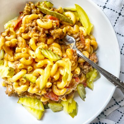 one pot cheeseburger pasta with pickles in a big white bowl