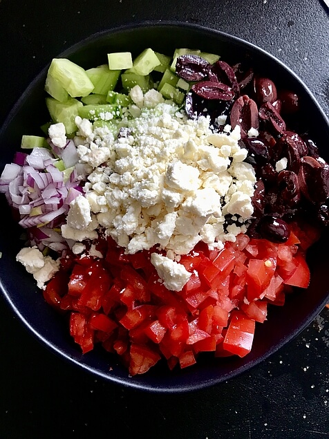 We see all the salad ingredients poured separately into a bowl but not yet mixed. Agsain, the mix of green, white, red, and purple are very striking.