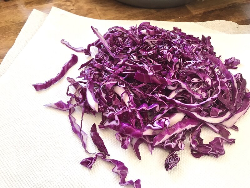 Strips of fresh chopped red cabbage laid out on a paper towel.