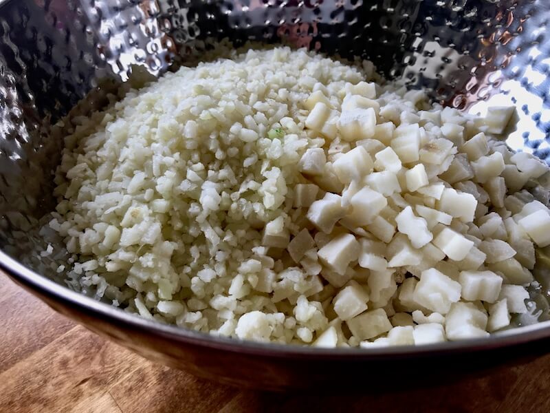 Step one - Frozen potato chunks and frozen riced cauliflower in a good-sized mixing bowl.
