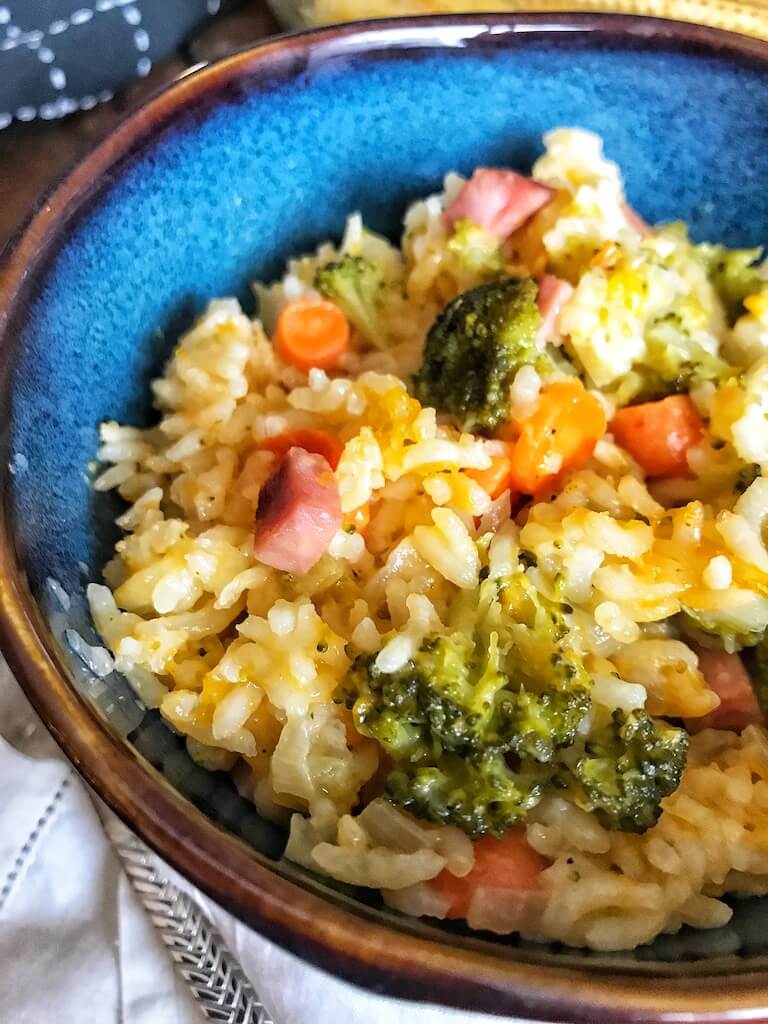Cheesy Ham and Broccoli Rice Casserole in a bright blue bowl 