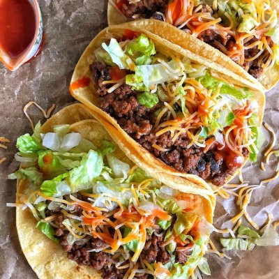 tortillas with beef and bean mixture and lettuce and cheese