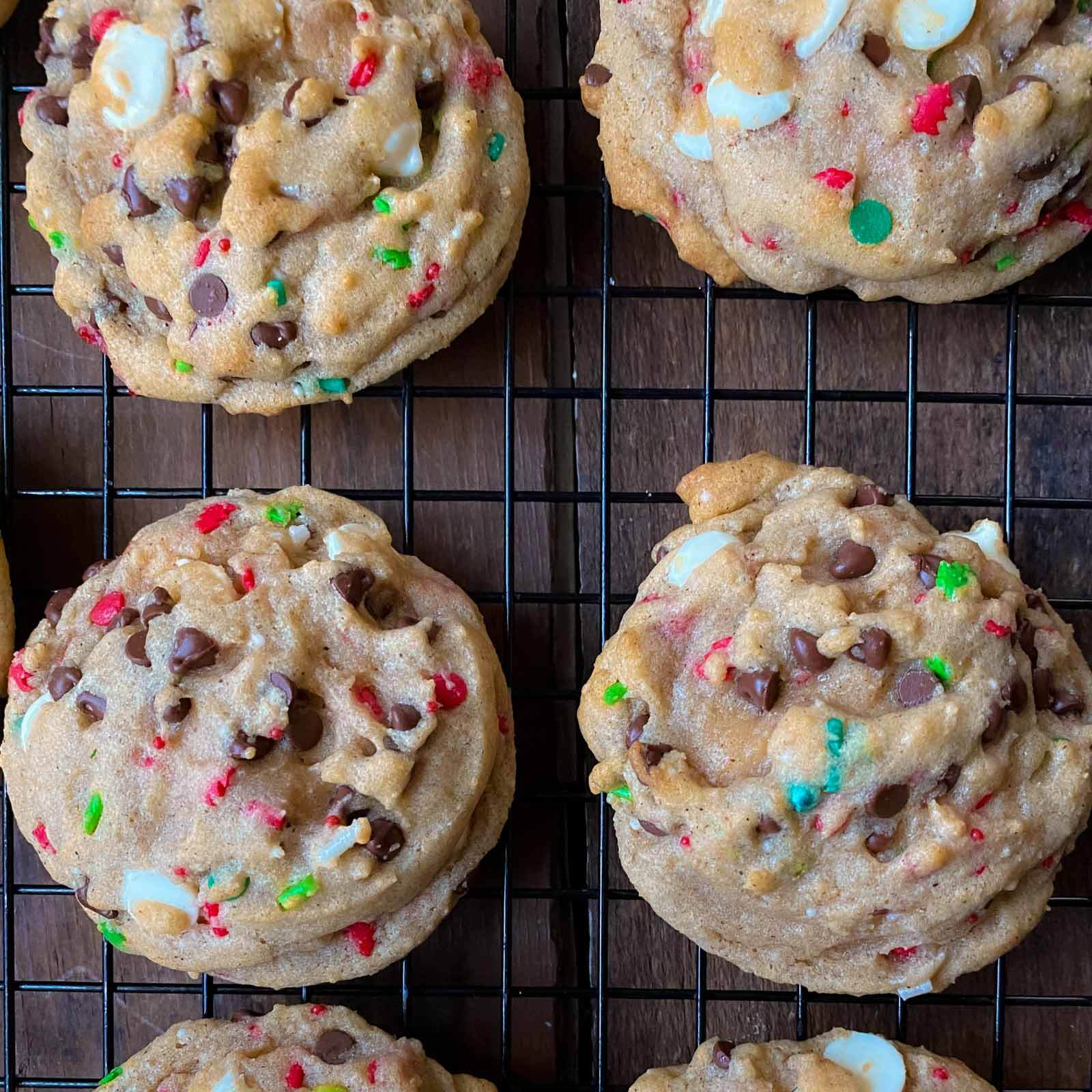 Christmas chocolate chip cookies with red and green sprinkles cooling on a rack.
