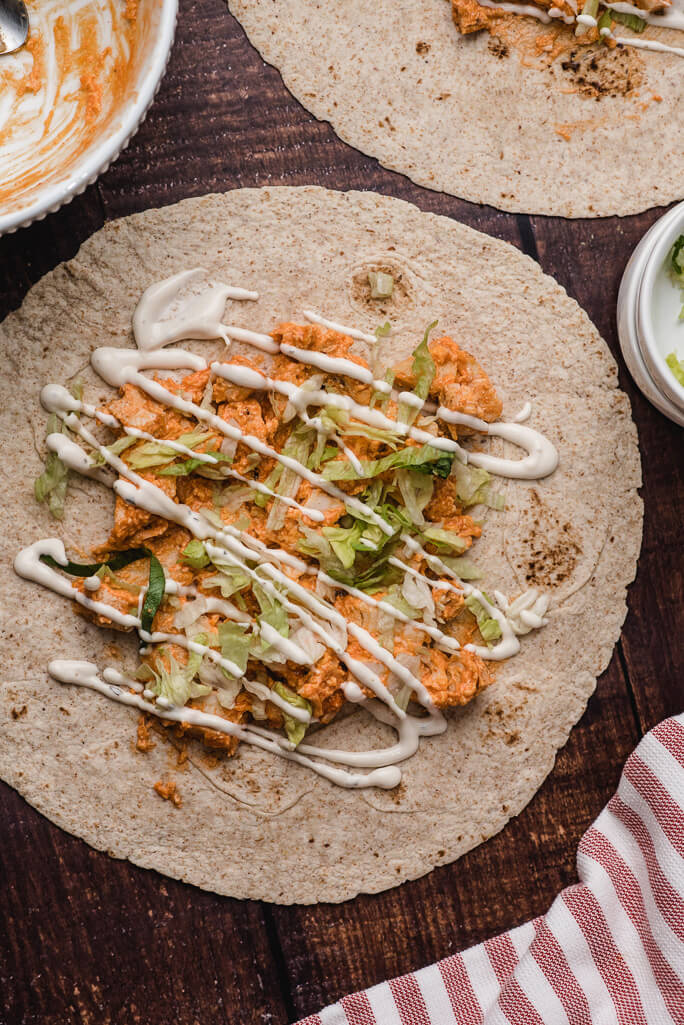 tortilla with buffalo chicken, lettuce, and ranch dressing drizzled  