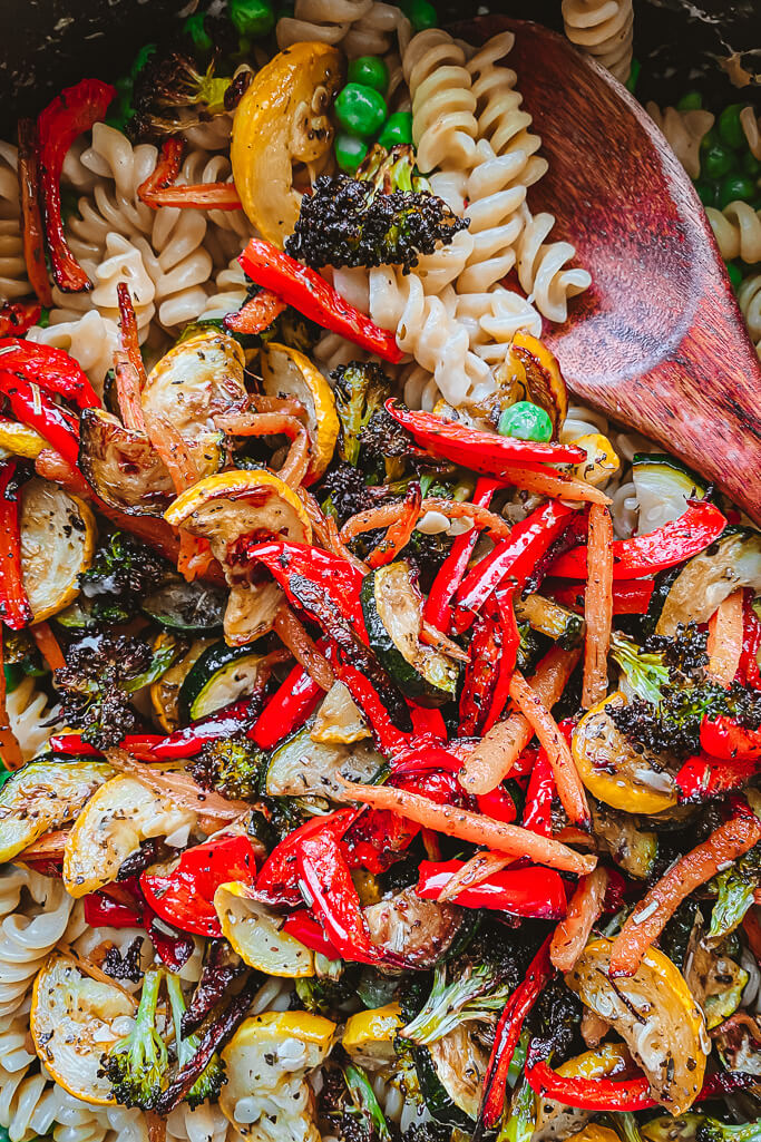 roasted vegetables with pasta and wooden spoon scooping