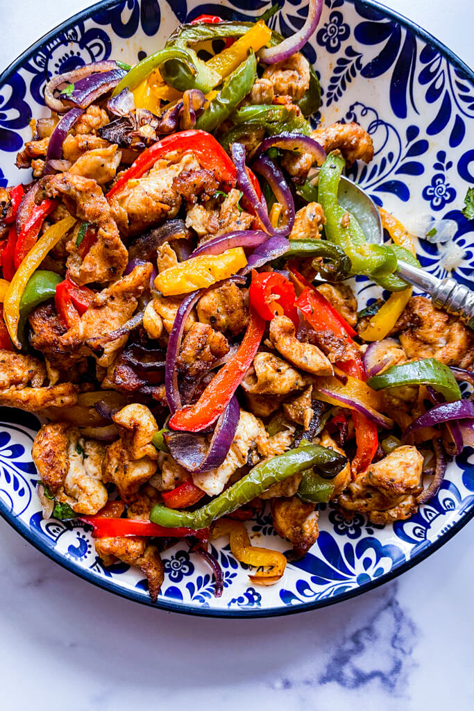 sliced chicken, green/yellow/red peppers, red onion in a blue floral bowl. Finished product: air fryer chicken fajitas 