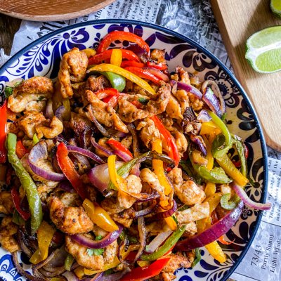 plate with fajitas chicken peppers and onion