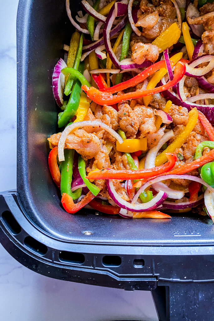 raw chicken, peppers, and onions in air fryer 
