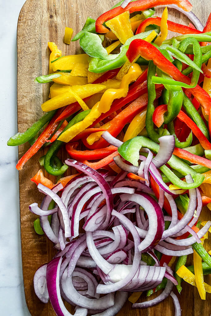 sliced red, yellow, and green peppers with red onions 