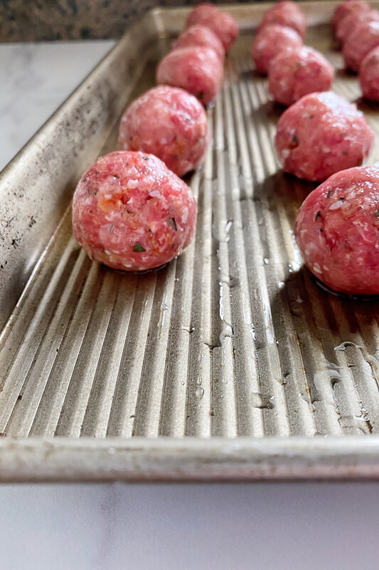 raw meatballs on sheet pan