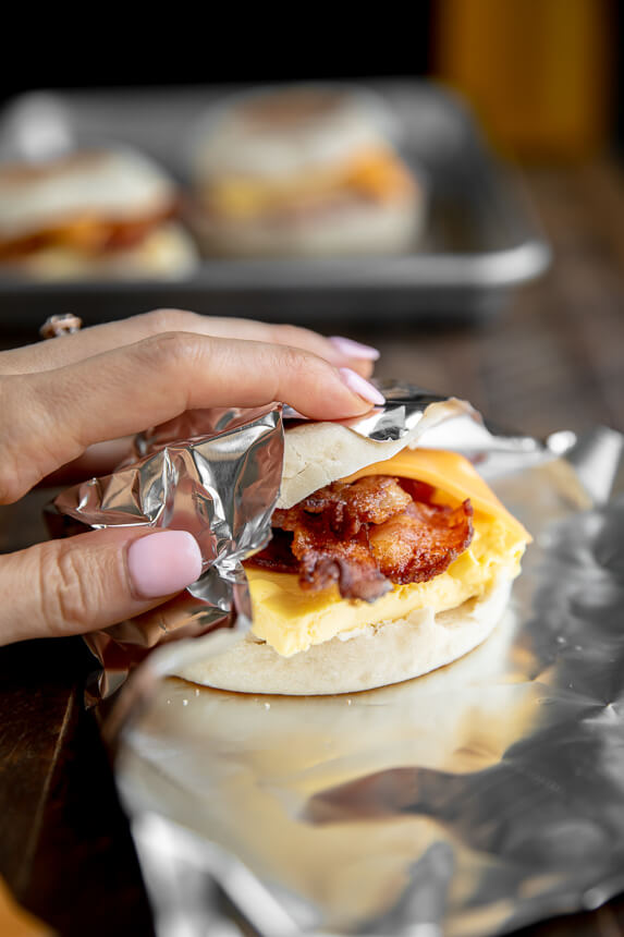 breakfast sandwich being wrapped in foil for the freezer