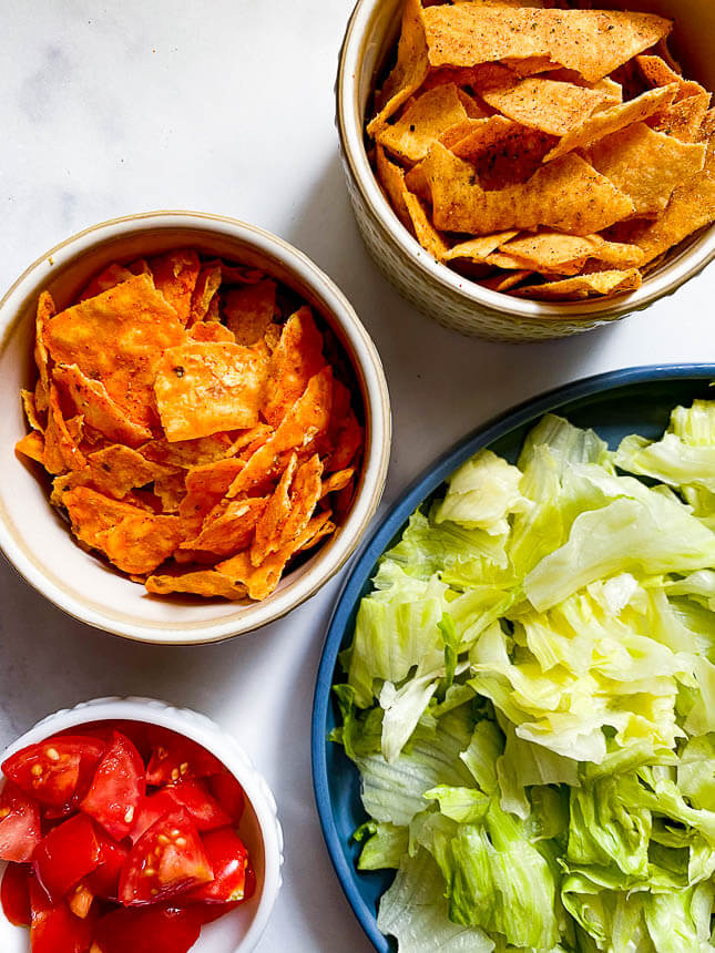pizza toppings: lettuce, Doritos, protein taco chips, chopped tomatoes