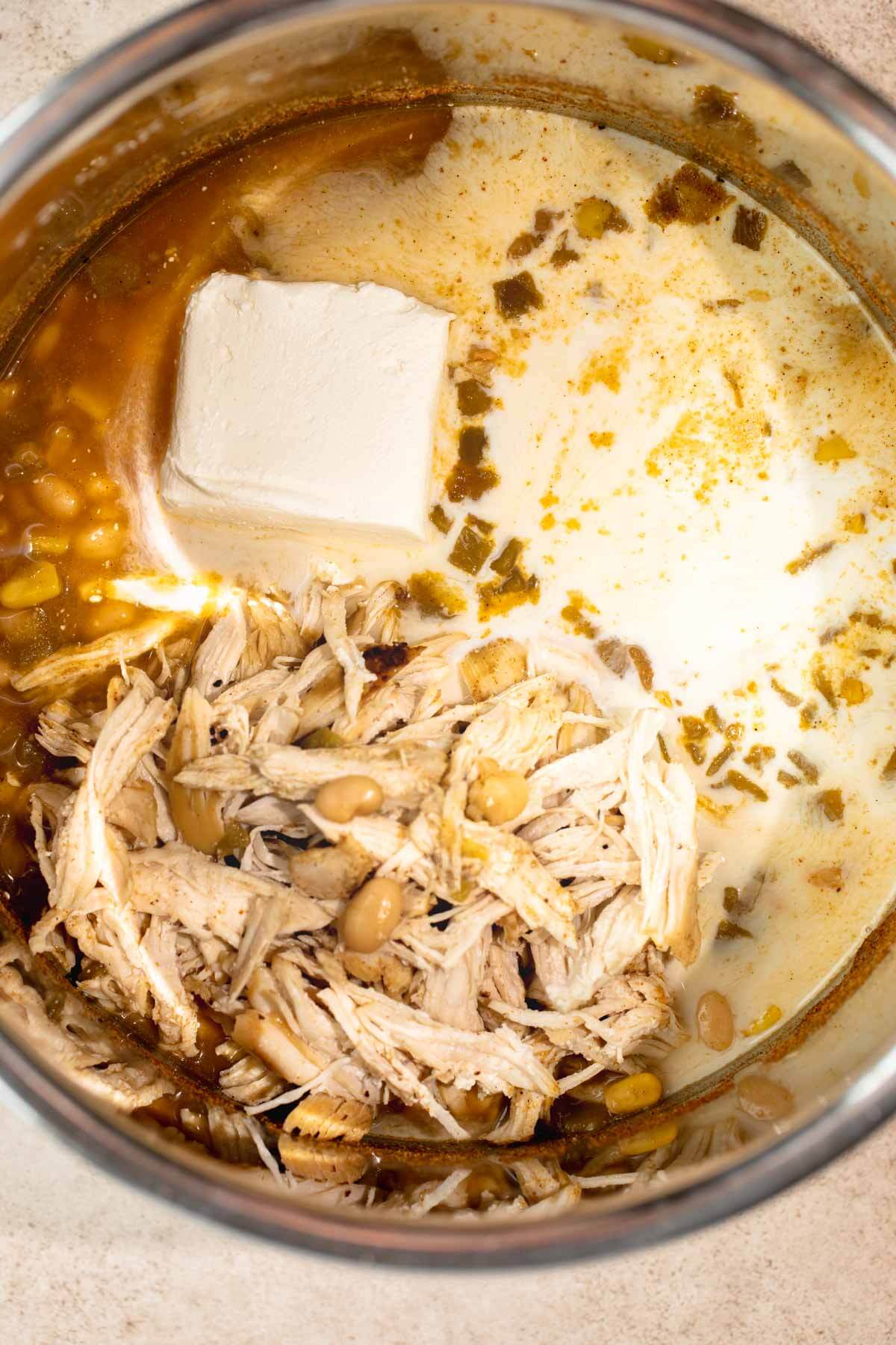 instant pot with shredded chicken, corn, cream cheese block
