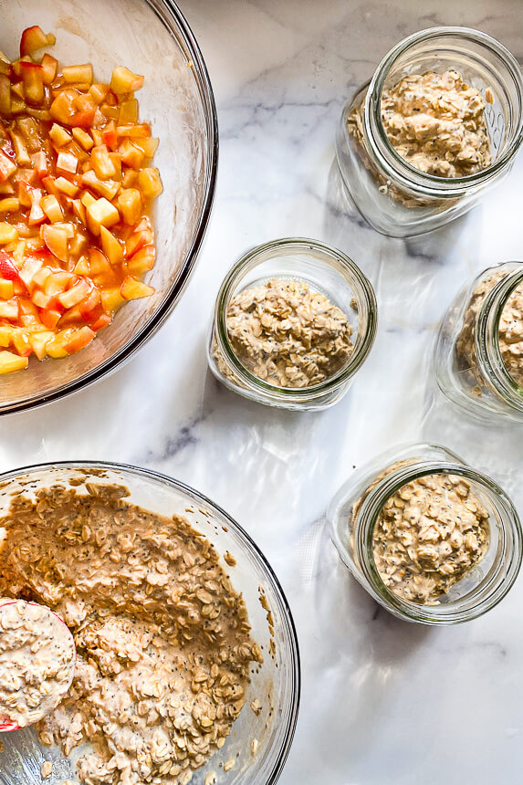 bowl of apple pie filling, bowl of oats, small jars of overnight oats