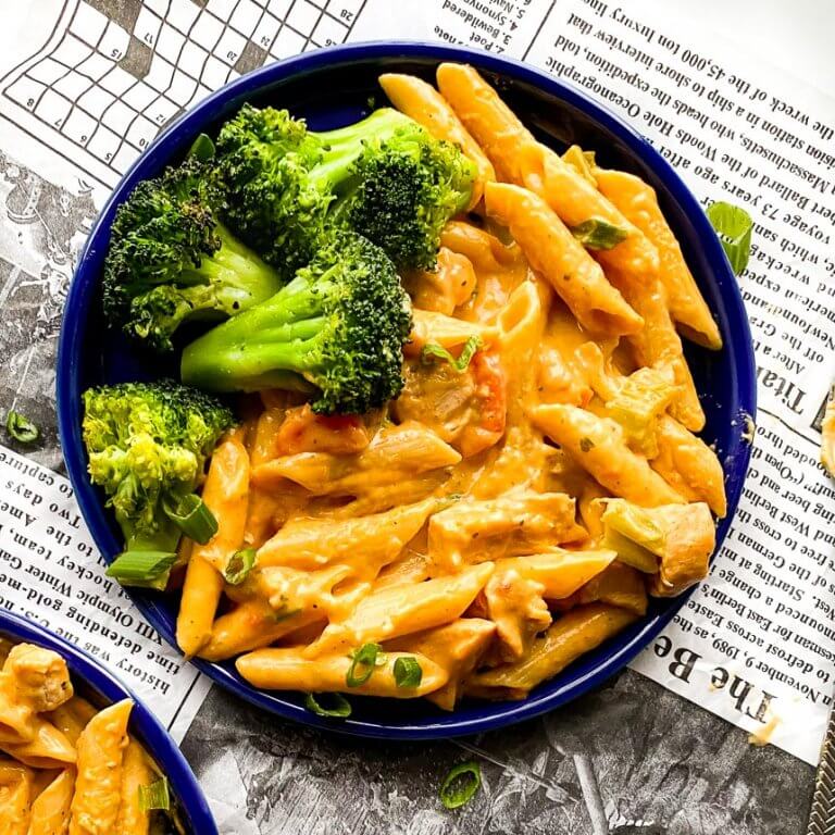 plate with buffalo chicken pasta and broccoli on the side