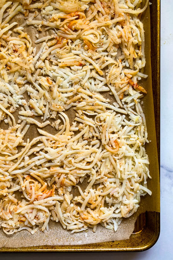 hash browns spread out on a sheet pan