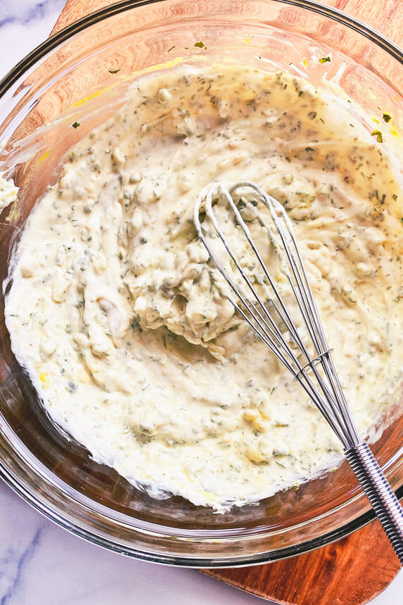 creamy salad dressing being whisked together in a bowl
