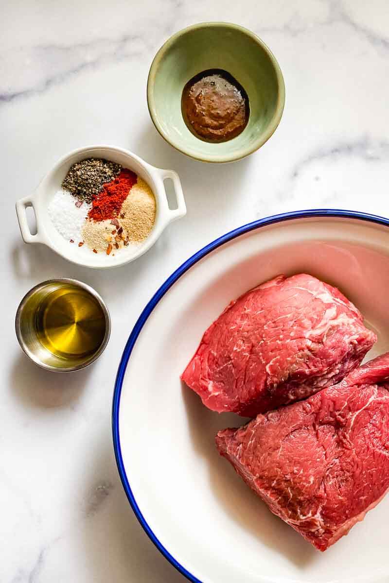 ingredients- sirloin steak in a bowl, seasonings in a bowl,  olive oil in a bowl, better than bouillon in a bowl