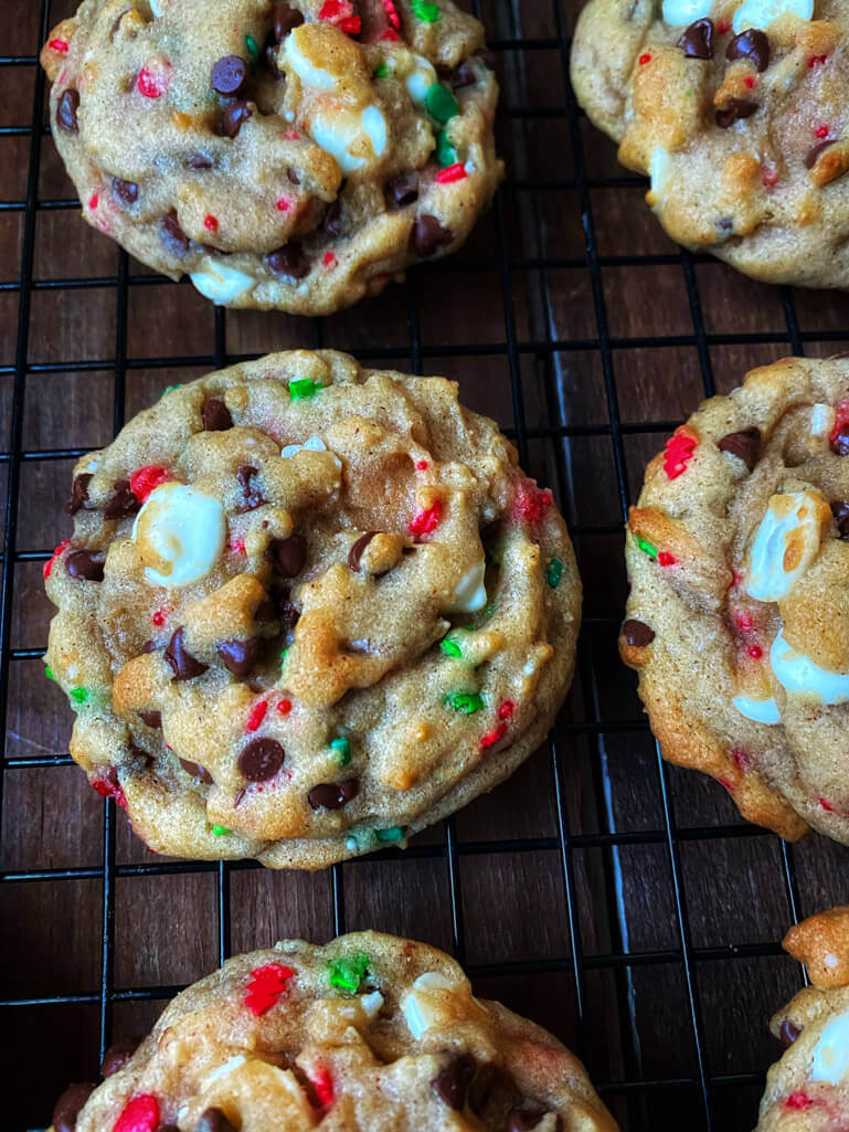chocolate chip cookies with bright red and green spinkles on a cooling rack