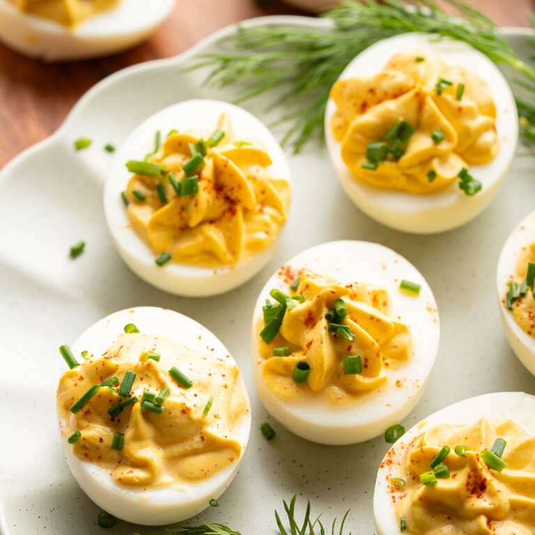 healthy deviled eggs with creamy cottage cheese filling topped with chives and paprika