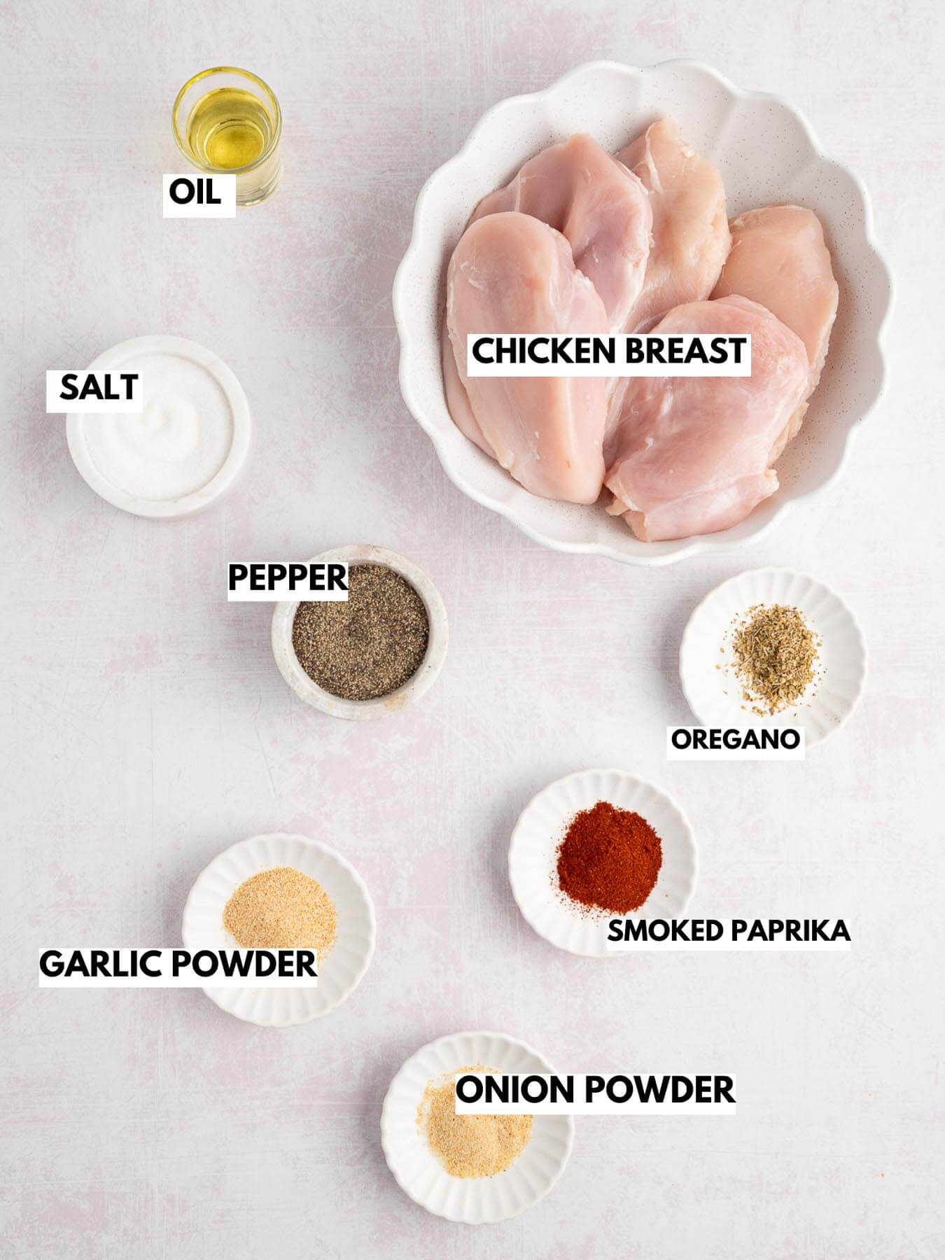 ingredients for baked chicken: chicken breast, oil, salt and pepper, smoked paprika, garlic powder, onion powder, and oregano