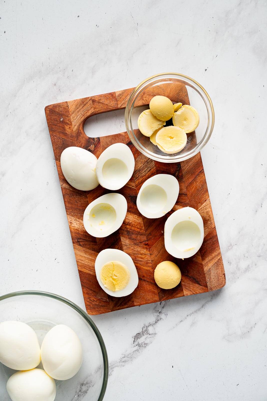 hardboiled eggs on a cutting board cut in half