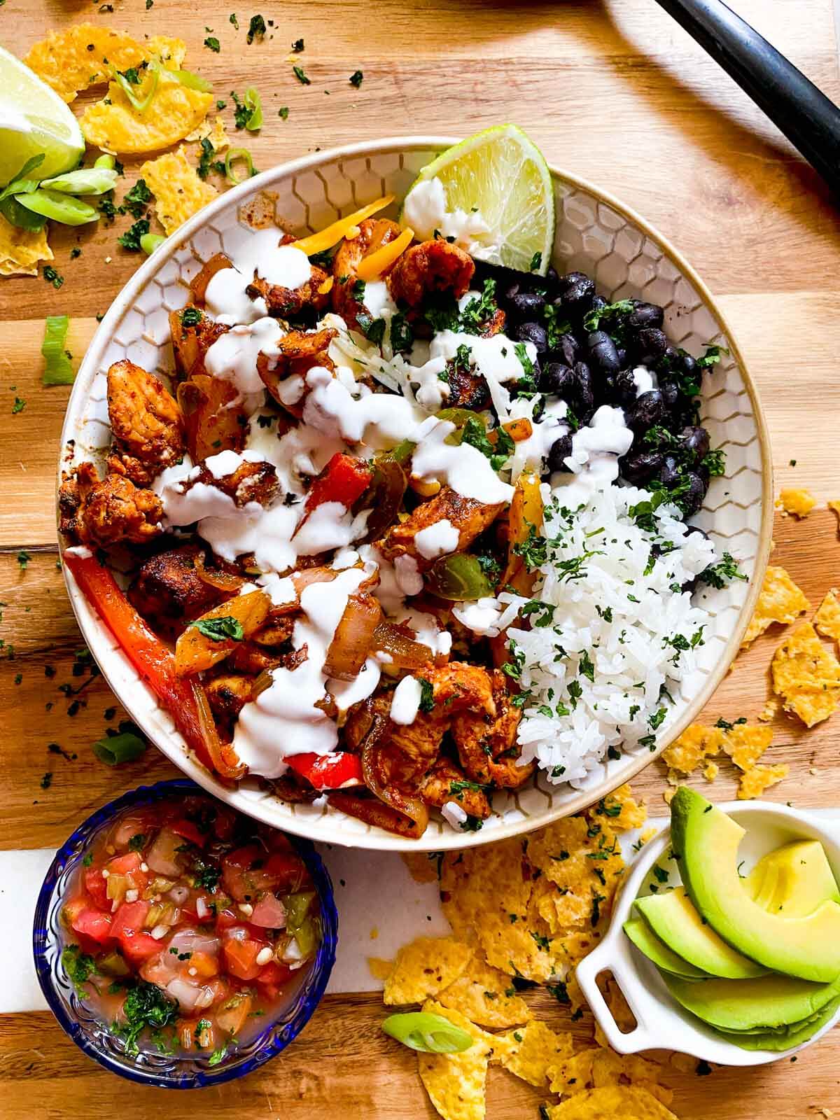 chicken fajita bowl with rice, black beans, and sour cream.