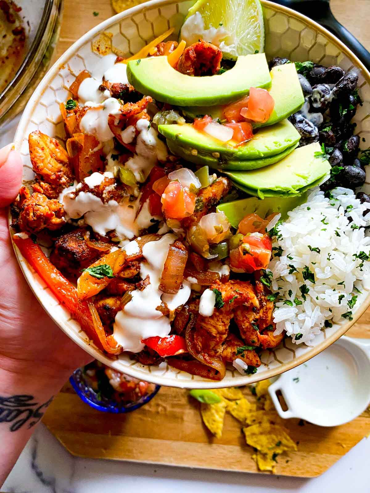 chicken fajita bowl with rice, beans, and sliced avocado.