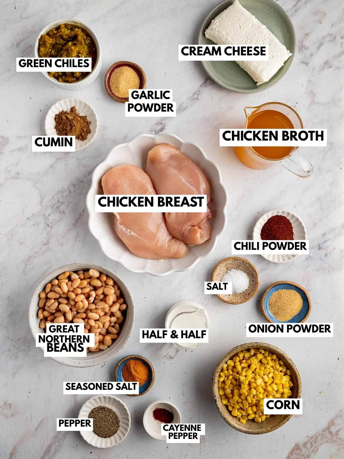 bowls of ingredients: chicken breast, green chiles, cream cheese, half and half, corn, beans, and an assortment of spices. 