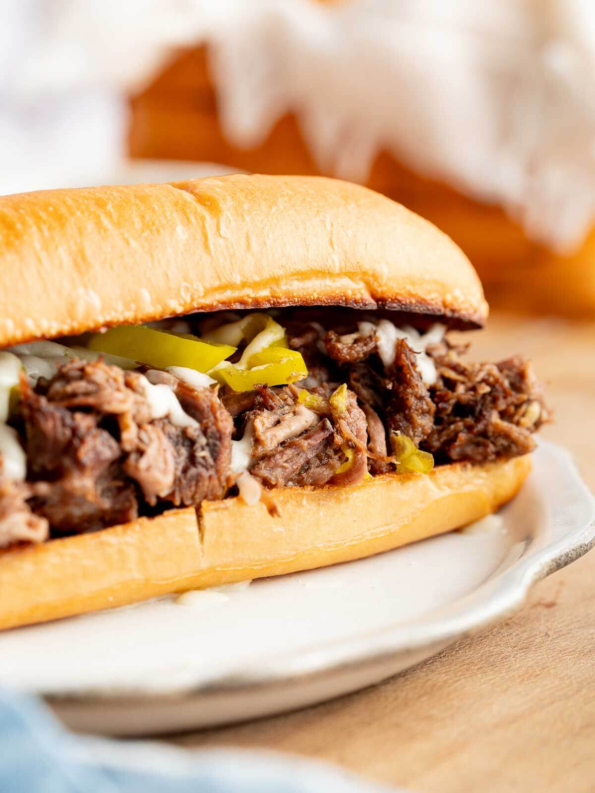 shredded slow cooker Italian beef with melted mozzarella on a sandwich.