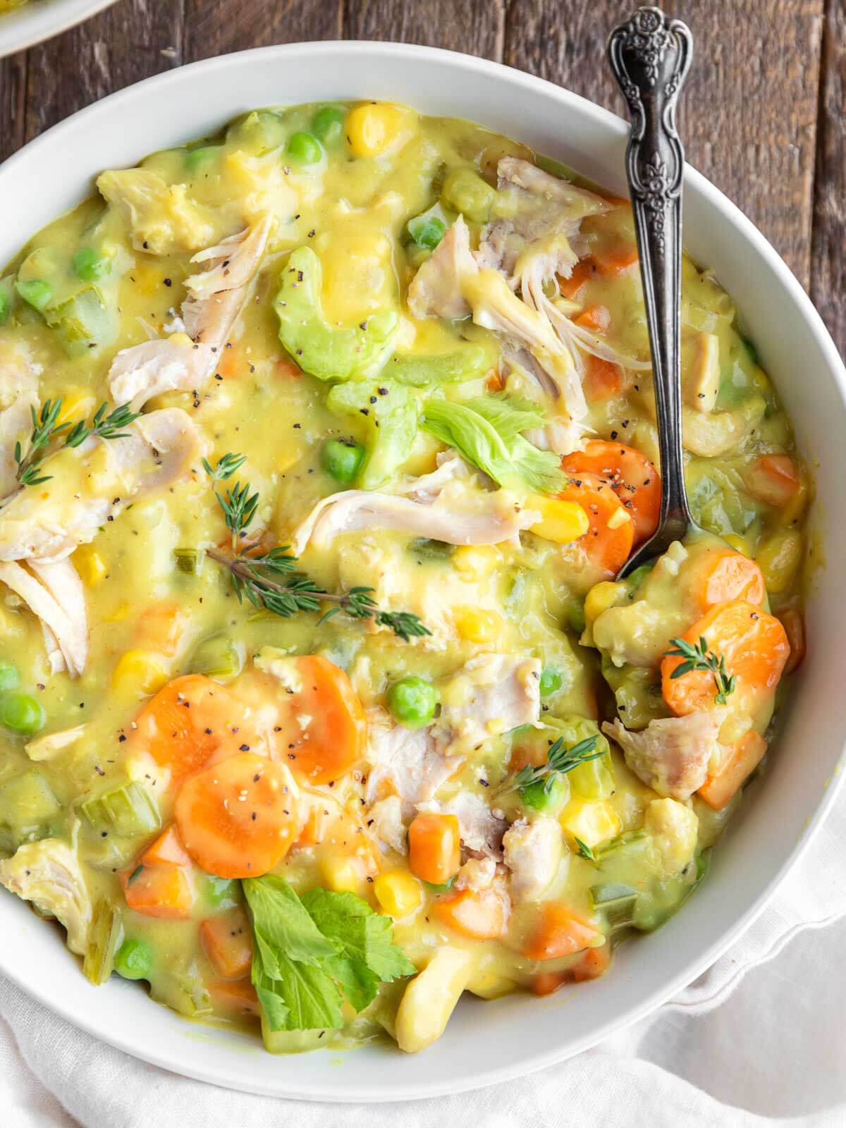bowl of creamy chicken pot pie soup with celery, carrots, and shredded chicken.