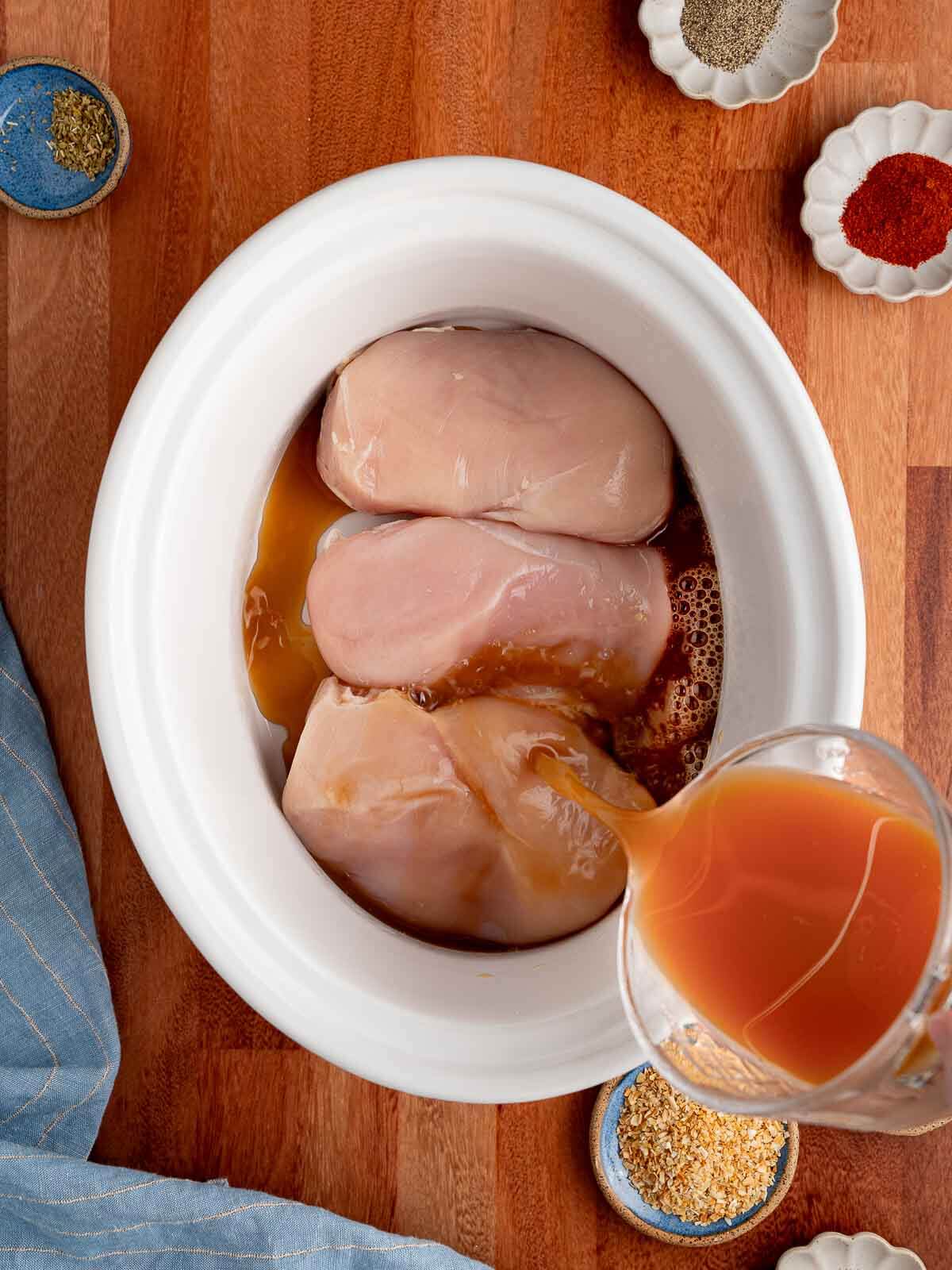 chicken broth poured into crockpot.