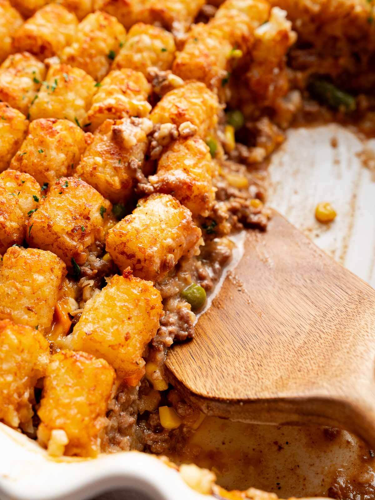 tater tot casserole in baking dish with spatula.