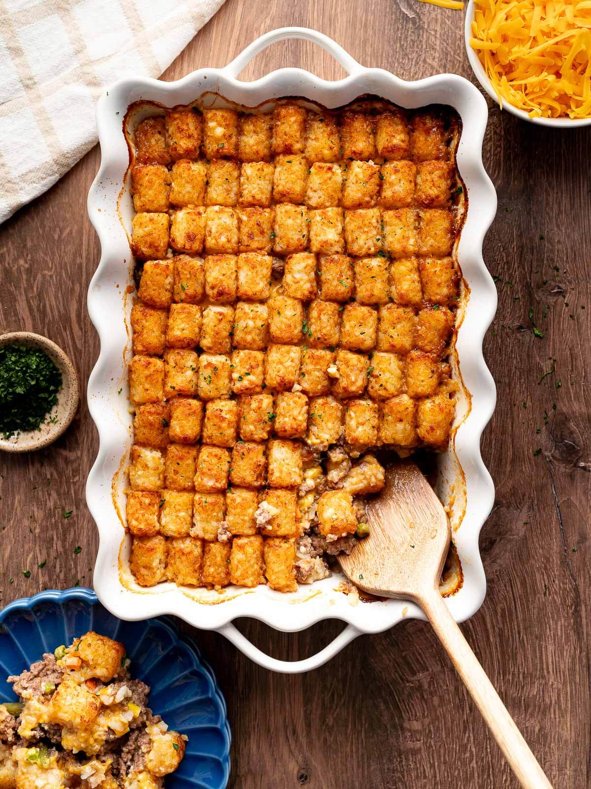 tater tot casserole with a piece being scooped out.
